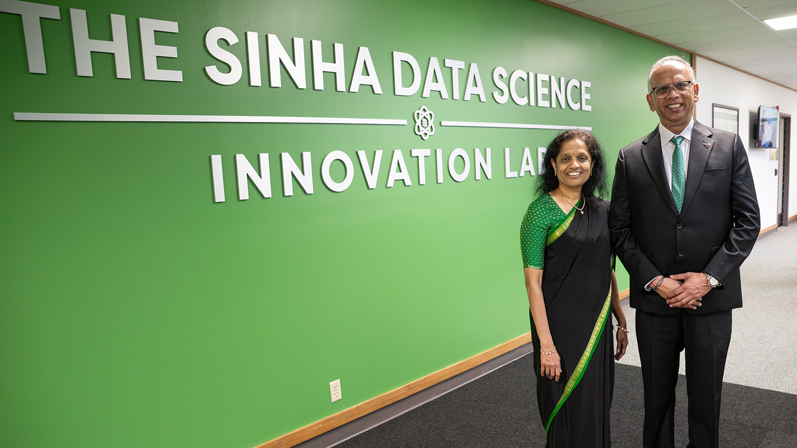 Vikas (’23 Ph.D.) and Anuradha Sinha stand in front of the sign that read The Sinha Data Science Innovation Lab